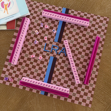 L'Été Indien Voyage travel mahjong mat styled on a table with a matching La Pochette pouch